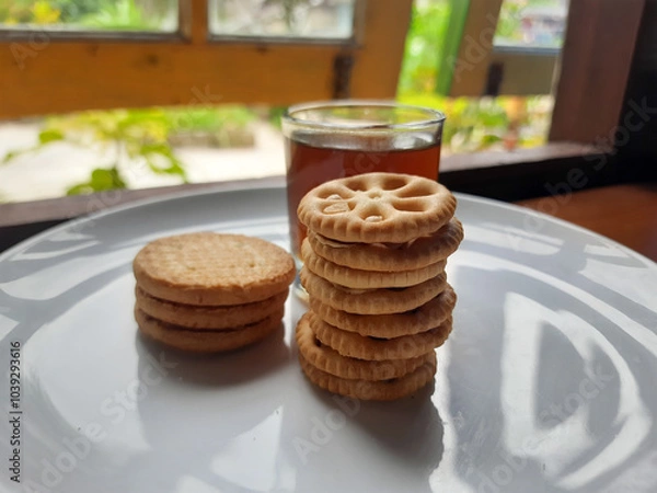 Fototapeta various kinds of biscuits that are usually eaten at breakfast accompanied by a glass of hot coffee on a white plate