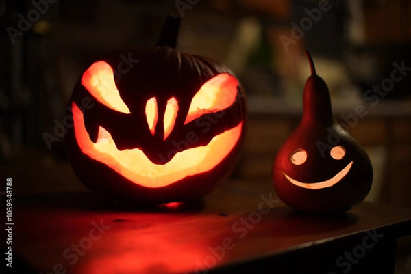Fototapeta Halloween pumpkins on dark dinner table at night. Shallow DOF.
