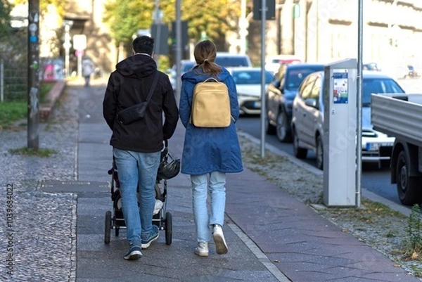 Fototapeta Parents with strollers on the sidewalk.