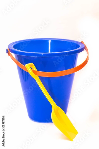 Obraz Blue sand bucket with yellow spade