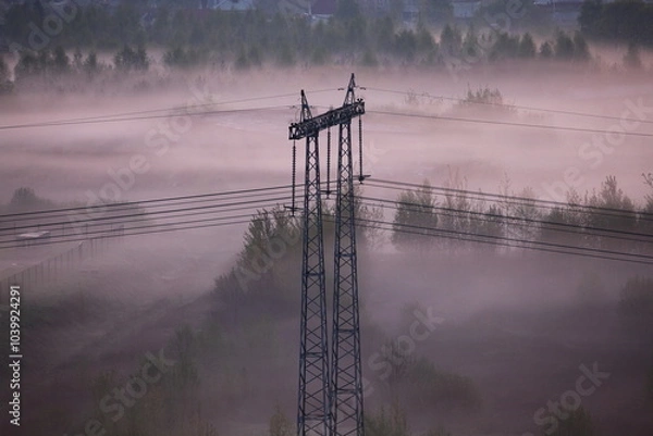 Fototapeta Electric tower and power line on field in fog