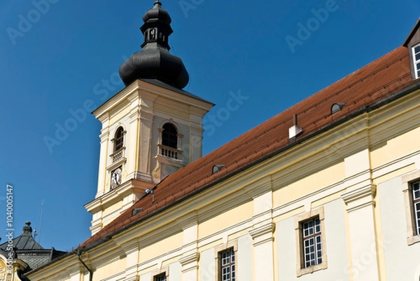 Fototapeta A baroque-style church tower in Sibiu, Romania, featuring an onion-shaped dome, a clock face, and arched windows.