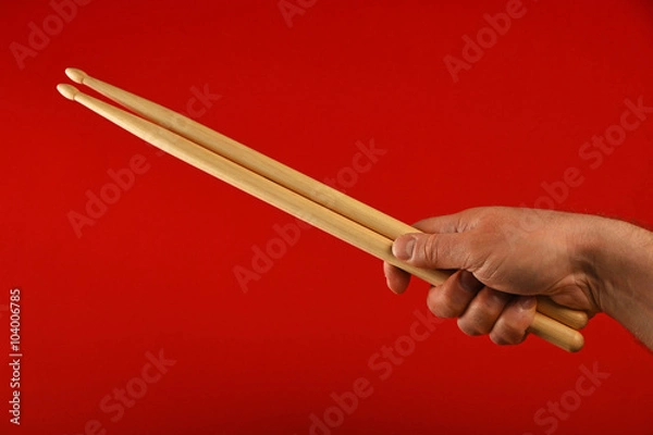 Fototapeta Man hand with drumsticks and devil horns over red