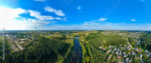 Fototapeta aerial drone view panorama landscape summer morning idyllic country side outskirts environment with river stream bridge and rural living cottages people settlement