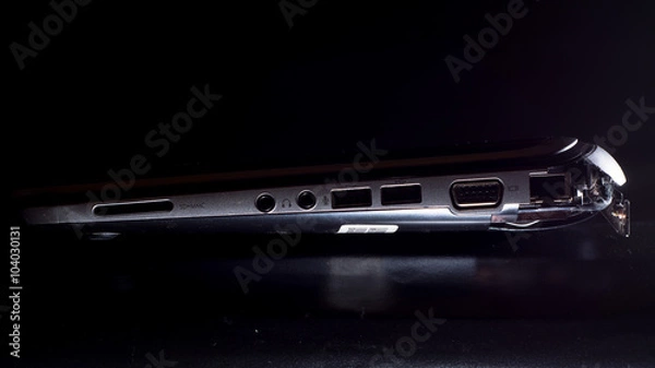 Fototapeta Laptop with broken outer casing wide. A computer with damage to shell after being dropped