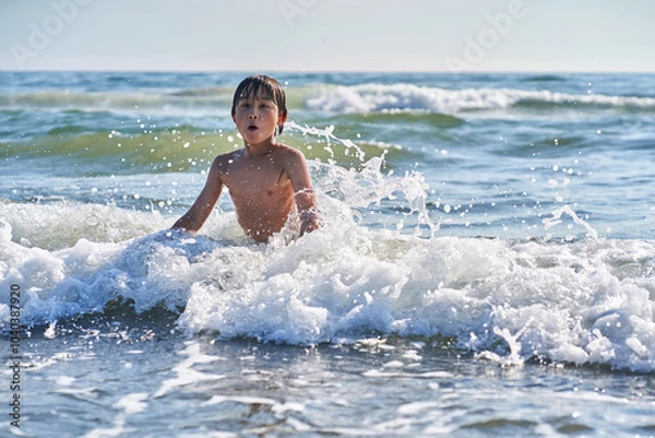 Obraz An 11 year old boy in having fun in the sea waves.