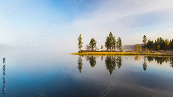 Obraz Quiet, calm and peaceful autumn frozen morning at the Finnish lake with breathtaking view to trees on shore with yellow grass mirrored in the calm surface of Luirojarvi lake in Lapland, Finland