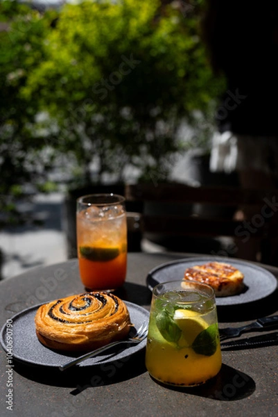 Fototapeta Enjoying delicious pastries and refreshing drinks in a cozy outdoor café setting on a sunny day