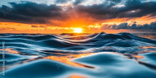 Fototapeta Nascer do sol brilhante refletindo em ondas calmas do oceano