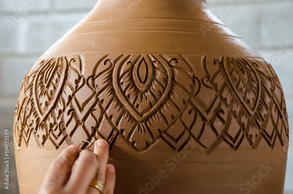 Obraz Hands of making clay pot on the pottery wheel ,select focus, close-up.