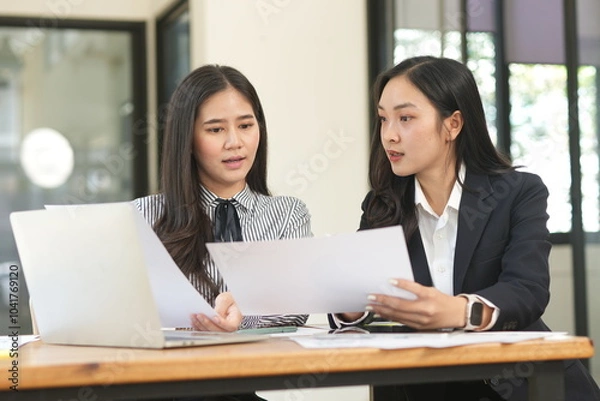Obraz Group of happy Asian business people having a meeting at the office. Two women working together using modern laptops.