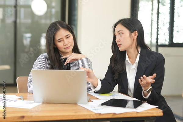 Obraz  Group of happy Asian business people having a meeting at the office. Two women working together using modern laptops.