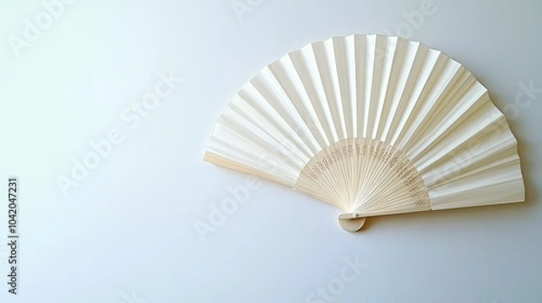 Fototapeta Flat lay of a traditional white folding hand fan, fully opened against a clean white background.