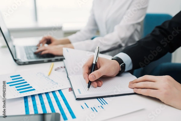 Fototapeta Man putting something down in his notebook