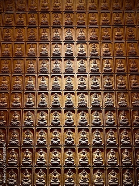 Fototapeta Intricate Wall of Buddha Carvings in a Grid Pattern Showcasing Spiritual Craftsmanship