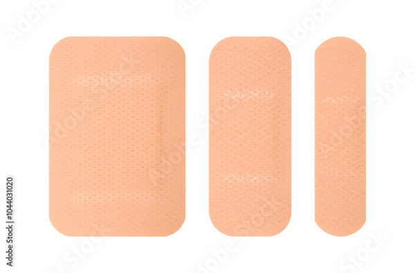 Obraz Three different sizes of skin toned adhesive bandages arranged side by side. The bandages have a perforated texture