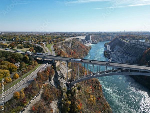 Obraz Aerial over the Niagara River and gorge, the international border crossing Queenston-Lewiston bridge between New York, United States and Ontario, Canada with hydroelectrical power plants, in autumn.