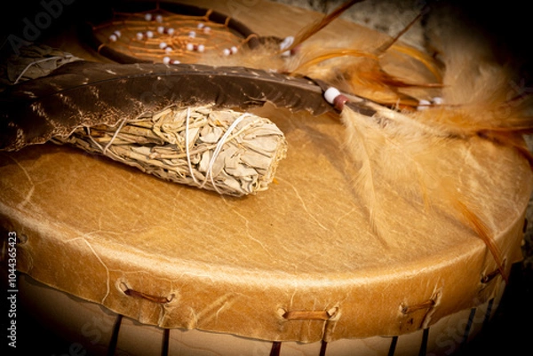 Fototapeta A close up image of a hand made leather meditation drum with white sage and dream catcher.