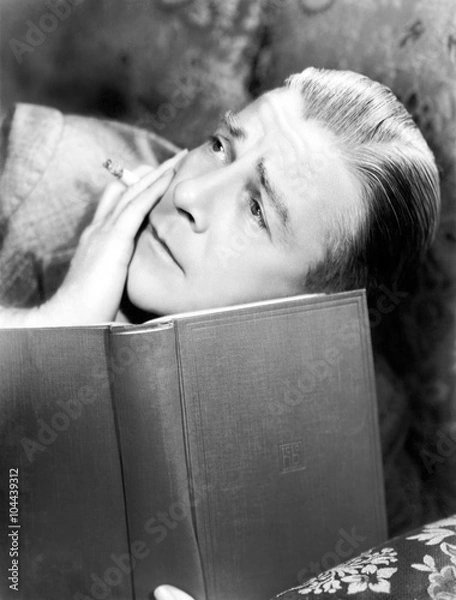 Fototapeta Man reading a book with a cigarette in a hand 