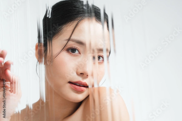 Fototapeta グレー背景で撮影をした若いアジア女性のスタイリッシュなスキンケアイメージ