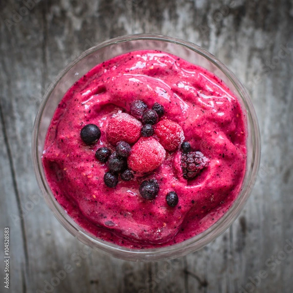 Fototapeta red smoothie with frozen berries, selective focus, top view