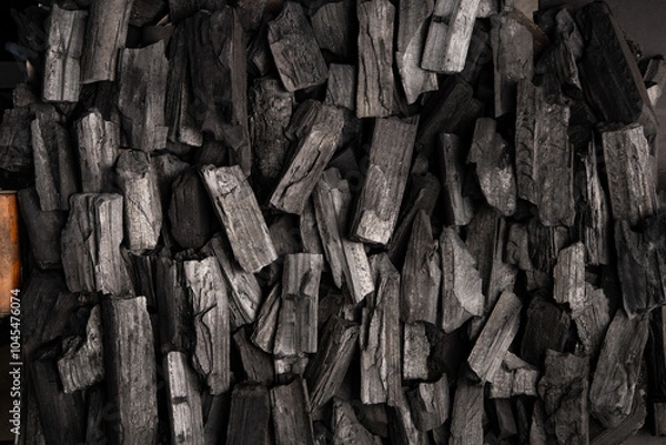 Obraz New, black coals, arranged in a neat bed, without embers. The pieces are lined up, ready to light, with a rough texture and dark hue