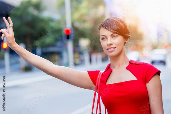 Fototapeta Businesswoman trying to catch a taxi