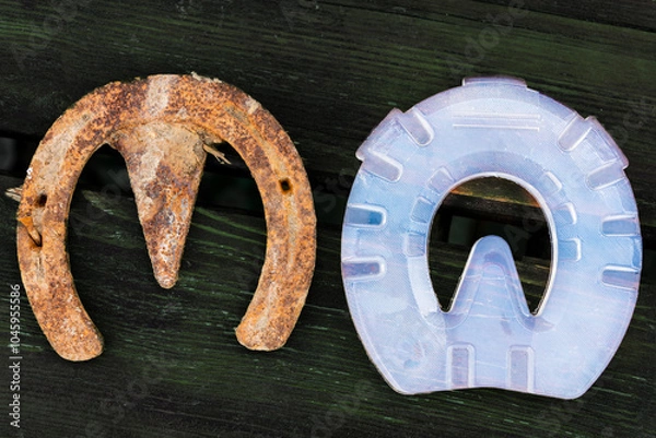 Obraz Old rusty iron horseshoe and modern plastic horseshoe made of composite material which provide better shock absorption and therapeutic support for the healing of the horse's hooves and legs