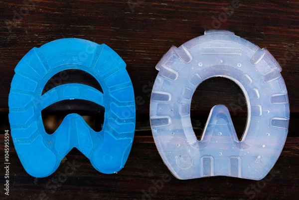 Obraz Modern plastic horseshoes made of composite material provide better shock absorption and therapeutic support for the healing of the horse's hooves and legs than traditional iron horseshoes.