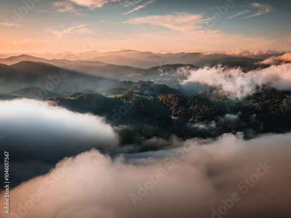 Fototapeta Sunset in the Mountains of Austria with fog filmed with a drone