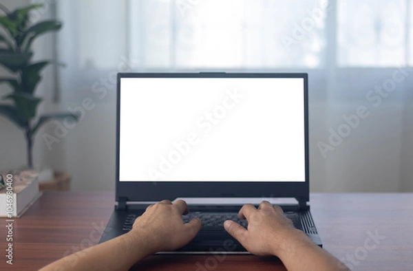 Obraz man's hands working on laptop in front of white