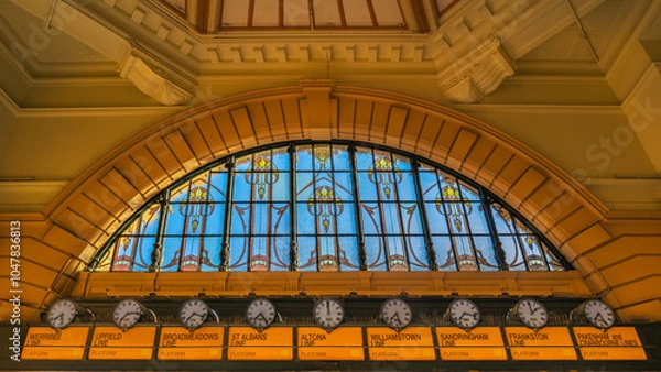 Obraz Inside the main entrance of Flinders Street Station in Melbourne, Australia showing the  impressive large stained glass window, clocks, and architectural details.