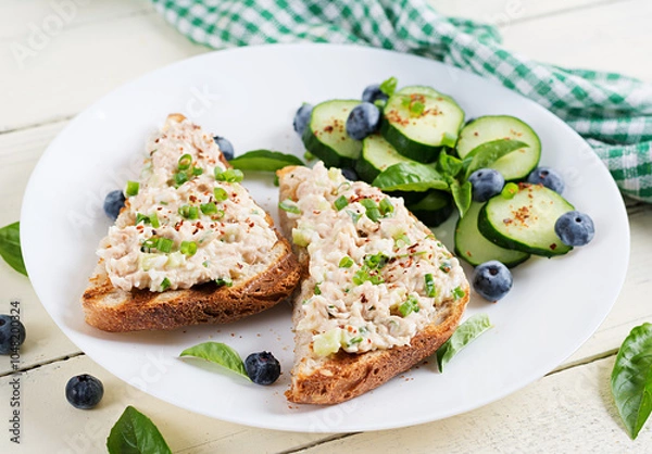 Fototapeta Toasts with tuna. Italian bruschetta sandwiches with pate canned tuna, egg and cucumber.