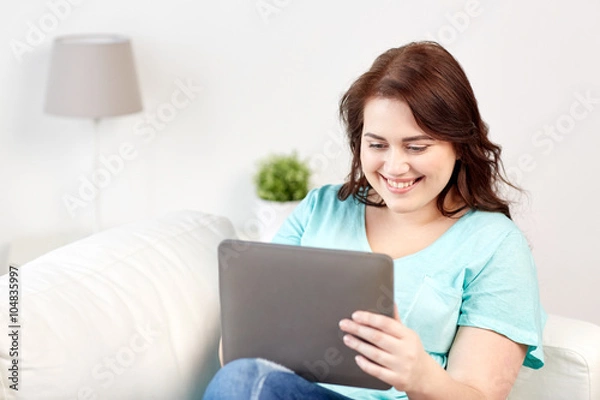 Fototapeta happy young plus size woman with tablet pc at home