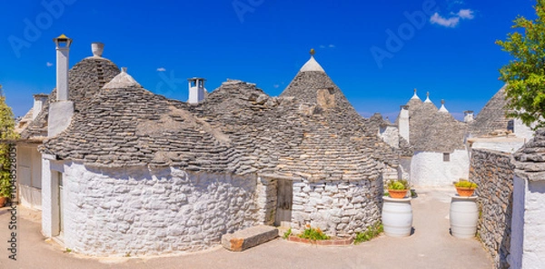 Obraz Trullo buildings in Alberobello  "beautiful tree"; The Famous town of the Metropolitan City of Bari, Apulia, southern Italy.  UNESCO World Heritage Site