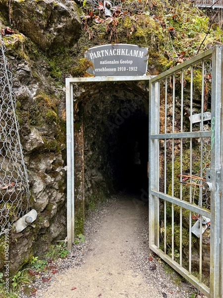 Fototapeta Garmisch-Partenkirchen, Germany - Nov 17 2022 : The entrance door leading through a cave to Partnachklamm Gorge, opening to stunning rocky cliffs and the sound of rushing water in Garmisch-Partenkirch