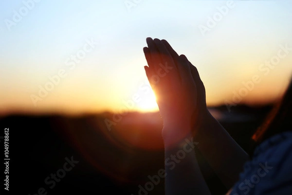 Obraz New Year sunrise rising sun background and shining light through praying christian hands, future hope and wish concept
