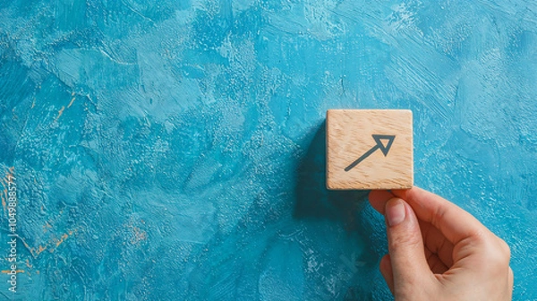 Fototapeta hand and a box with an arrow on the blue wall
