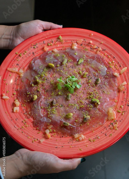 Obraz Hands Holding Plate of Mediterranean Tuna Carpaccio