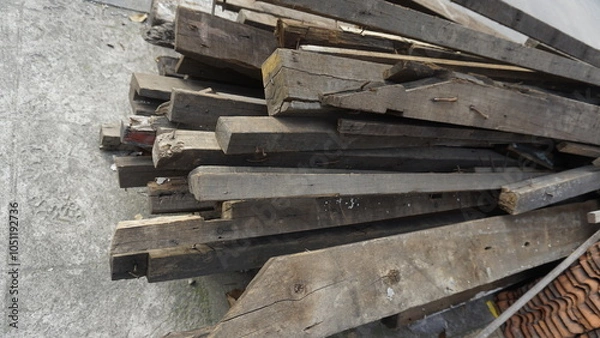 Fototapeta Obsolete piles of wood placed on the side of the road to be transported by transport vehicles
