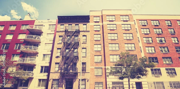 Fototapeta Vintage toned photo of New York building with fire escape ladder.
