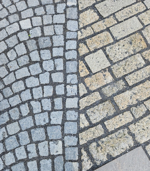 Fototapeta Top view of the cobblestone flooring with small gravel grouting on the street of western Europe