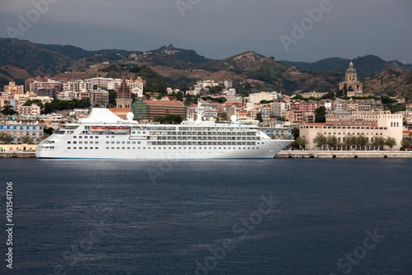 Fototapeta View of the city of Messina in Sicily from the strait. A cruise liner in front of it.