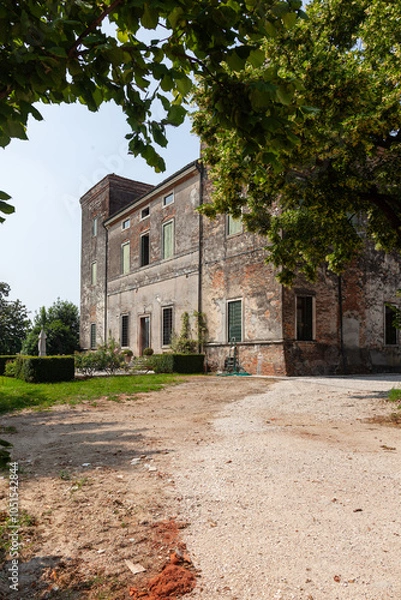 Fototapeta View of an Italian villa and the road leading to it through the trees.