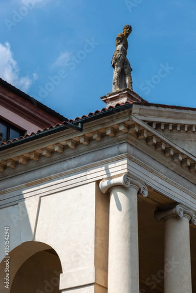 Fototapeta This grand villa showcases Palladian architecture with a stately colonnade, sculpted statues on the roofline, and arched entrances. A serene garden and central well enhance the classical ambiance.