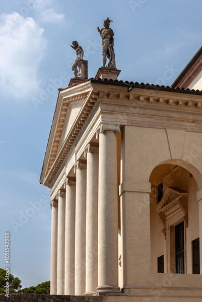 Fototapeta This grand villa showcases Palladian architecture with a stately colonnade, sculpted statues on the roofline, and arched entrances. A serene garden and central well enhance the classical ambiance.