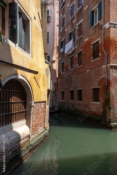 Fototapeta View of a Venetian canal. Two old Venetian houses standing on the canal.