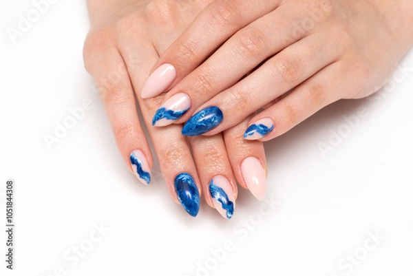 Fototapeta Blue smoky manicure with abstraction on long sharp nails close-up on a white background. Festive nail design