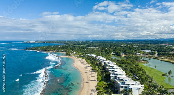 Obraz An aerial view of west beach residences Dorado Beach Resort in Puerto Rico, capturing both the coastline and the adjacent golf course. To the left, the coastline runs along the blue waters.
