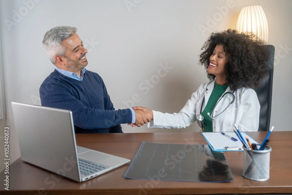 Fototapeta Happy smiling man shaking hands with physician after visit to clinic. He is feeling very grateful for receiving medical treatment. Copy space  